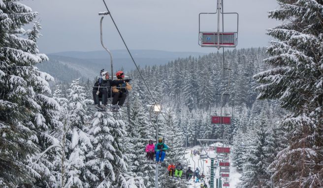 Skifahrer sitzen in einem Skilift. Trotz verschärfter Corona-Regeln können Skifahrer die Lifte in Thüringen mit 3G-Nachweis nutzen. 