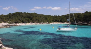 Während die Strandbesucher wie Sardinen in der Dose am Strand liegen, ankert das Segelboot in der Cala en Turqueta rund 150 Meter vom Strand entfernt.