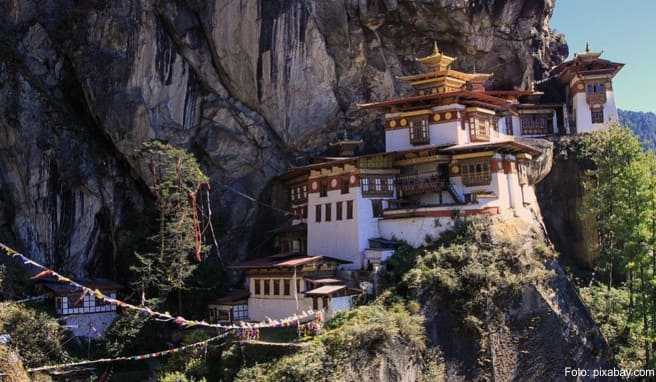 Sie klammern sich in den Fels, als hätten sie Angst, herauszufallen: die weißen Häuser des Tigernest-Klosters 900 Meter über der Fußsohle des Paro-Tals in Bhutan
