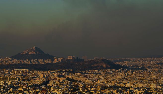 Eine Gesamtansicht von Athen mit dem Akropolis-Hügel (M), während ein Feuer im nördlichen Teil der Stadt brennt. Nur wenige Kilometer nordöstlich der griechischen Hauptstadt bekämpft die Feuerwehr auf einer Fläche von rund 200 Quadratkilometern unzählige Brandherde.