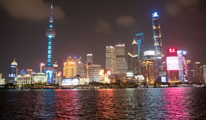 Pudong auf der anderen Seite des Huangpu-Flusses: abendlicher Ausblick von Shanghais Uferpromenade The Bund aus.