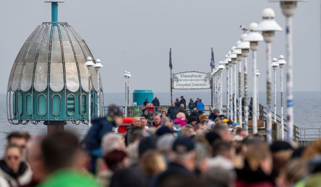 Ostern an die Ostsee? Touristen sind bei sonnigem Wetter im Ostseebad Zinnowitz auf der Seebrücke unterwegs.